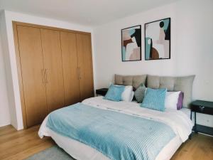 卡萨布兰卡Cosy apartment with terrasse at in CFC的一间卧室配有一张带蓝色枕头的大床