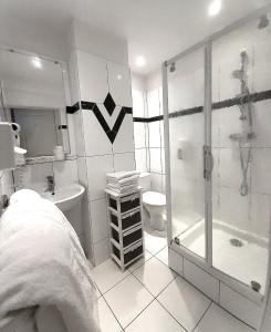 翁弗勒尔叠水瀑布 – 迷人酒店的带淋浴、卫生间和盥洗盆的浴室