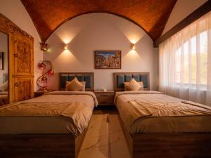 Qasr Al FarafirahB&W SAHARA SKY CAMP的一间卧室设有两张床和大窗户