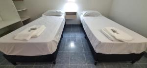 拉里奥哈COMPLEJO TURISTICO RIOJA的小客房内的两张床和毛巾