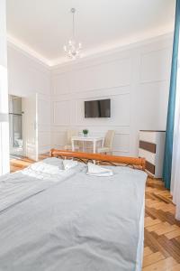 克拉科夫ROYAL Apartments的白色卧室配有床和桌子