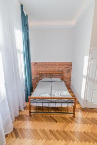 克拉科夫ROYAL Apartments的砖墙房间的一个床位