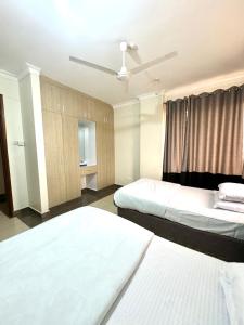 VoiHillsview Apartment的酒店客房配有两张床和吊扇。