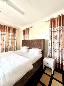 VoiHillsview Apartment的一间卧室配有一张带窗帘的大床