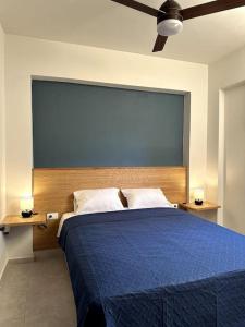 MódhionSunny flat among olive trees, next to the beach的一间卧室配有一张带两盏灯的大蓝色床。