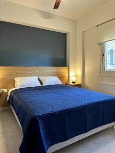 MódhionSunny flat among olive trees, next to the beach的一间卧室配有一张带蓝色毯子的大床