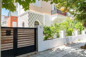 科斯镇Kosnian City Suites B的白色房子前面的黑色大门
