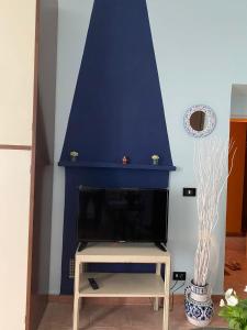 Vaglio SerraA casa di Anna的客厅设有壁炉和蓝色的墙壁