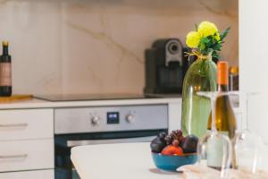阿利若CASAS DA RUA NOVA的厨房柜台,配有花卉和水果花瓶