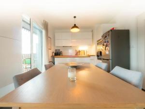 蒙彼利埃Le Ray Charles - Terrasse - Port Marianne的厨房配有木桌、椅子和冰箱