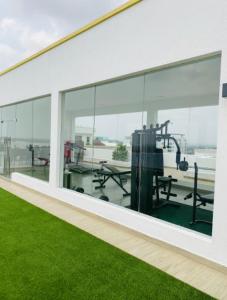 阿克拉Accra Luxury apartments at Oasis Park Residences的一座空的建筑,有玻璃窗,绿草成荫