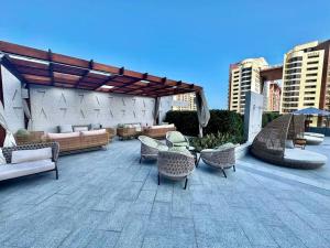 迪拜Luxury Studio in High Floor Full Sea View in The Palm Tower Plam Jumeirah的一个带柳条椅和桌子的庭院和一个凉亭