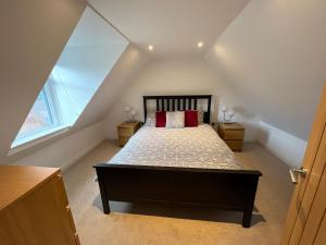伊文格瑞Alt-Na-Slat Cottage的阁楼卧室配有带红色枕头的床