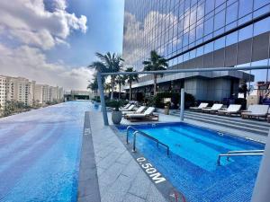迪拜Luxury Studio in High Floor Full Sea View in The Palm Tower Plam Jumeirah的大楼一侧的大型游泳池