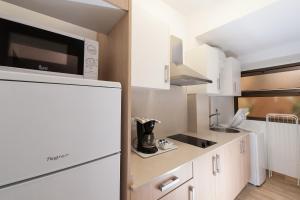 大加那利岛拉斯帕尔马斯拉斯帕尔马斯城市中心酒店的厨房配有白色橱柜和冰箱。