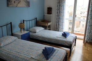 雅典Mona Hause的一间卧室设有两张床和窗户。