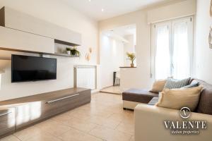 维亚雷焦Viareggio - Via Pisano 61 Valente Italian Properties的一间带电视和沙发的客厅