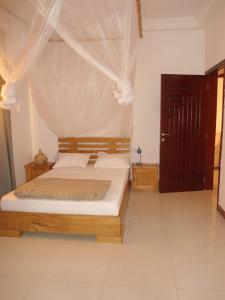 达喀尔Daaru Jamm的一间卧室配有一张带蚊帐的床