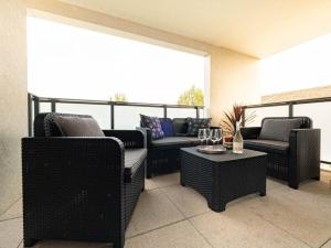 Le CrèsL'héliade - Climatisation et parking的阳台配有沙发和带酒杯的桌子。