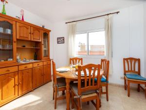 兰卡Apartment Cap Ras II by Interhome的一间带木桌和椅子的用餐室