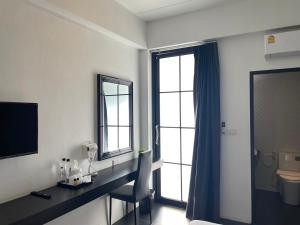 清迈Azz Hotel的一间带书桌、卫生间和窗户的浴室