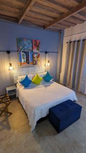卡塔赫纳马洛卡精品酒店的一间卧室配有一张带蓝色和黄色枕头的大床