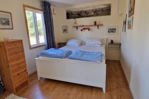 福勒Fantastiskt hus på fårö的一间卧室配有白色的床铺和蓝色的床单