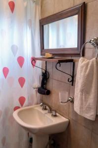 波特雷里约斯Cabañas Rowal的一间带水槽的浴室和窗帘上带心的窗户