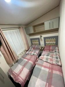 布伦特山庄Cosy Holiday Home, Home Farm Holiday Park的小型客房 - 带2张床和窗户