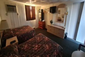 杜波依斯DuBois Manor Motel by OYO的酒店客房设有两张床和电视。