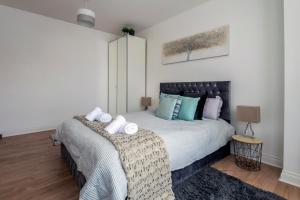 伦敦Woodside Gardens Luxury Properties的一间卧室配有一张带蓝色枕头的大床