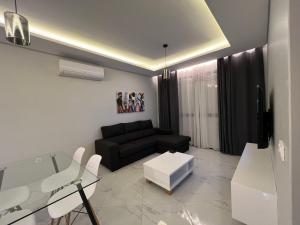 普拉亚Santos House Praia的客厅配有黑色沙发和玻璃桌