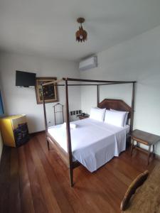 欧鲁普雷图Pousada Solar da Inconfidencia - By UP Hotel - fácil acesso a Praça Tiradentes的一间卧室设有一张天蓬床和木地板。