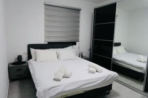 Poriyyaאחוזת העמק סוויטות בפוריה的一间卧室配有一张带白色床单和镜子的床