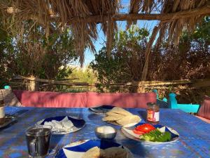 Al QaşrBeir El Gabal Hotel (with Hot Springs)的一张蓝色桌子,上面放着食物板