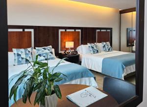 曼塔海菊蛤珍珠酒店的酒店客房设有两张床和一张桌子。