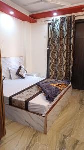 新德里Hotel Royal Inn的一间卧室配有一张带窗帘的大床