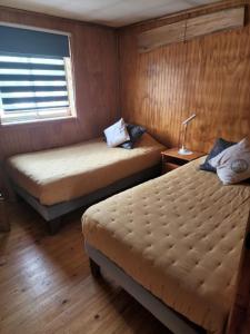 科伊艾科Ruta Austral - Coyhaique的小型客房 - 带2张床和窗户