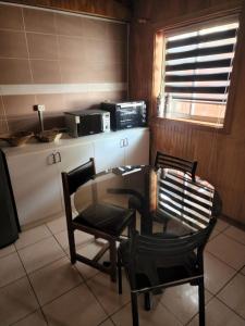 科伊艾科Ruta Austral - Coyhaique的厨房配有桌子、两把椅子和微波炉