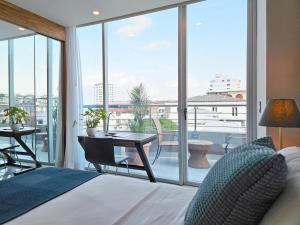 曼塔海菊蛤珍珠酒店的一间卧室配有一张床,阳台配有桌子