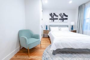 布鲁克林323-1 Specious 2BR Williamsburg的一间卧室配有一张床和一张蓝色椅子
