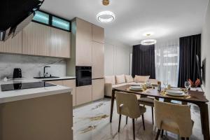 华沙Airport Apartment - Private Terrace & Parking - by Rentujemy的厨房以及带桌椅的起居室。
