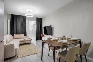 华沙Airport Apartment - Private Terrace & Parking - by Rentujemy的客厅配有桌子和沙发
