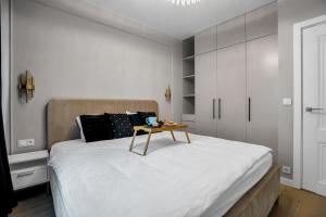 华沙Airport Apartment - Private Terrace & Parking - by Rentujemy的一间卧室配有一张桌子和一张床铺