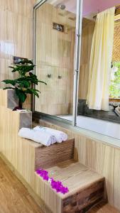 巴尼奥斯Balcones del Paraíso的浴室设有淋浴、镜子和紫色鲜花