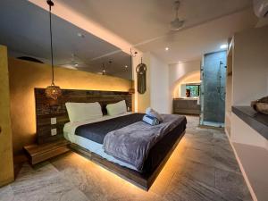图卢姆Kuun Taak Tulum的一间卧室设有一张大床和一个步入式淋浴间。