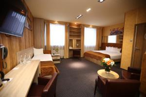 皮拉福马酒店的酒店客房带两张床和一张桌子以及椅子。