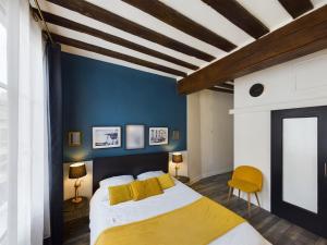 特鲁瓦Studio Deschainets Troyes Gare et Centre Historique的一间卧室设有一张床和蓝色的墙壁