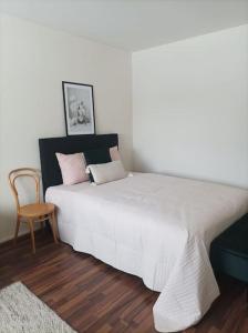 黑诺拉Viihtyisä ja valoisa yksiö keskustan läheisyydessä的卧室配有一张白色大床和一把椅子