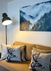 布勒伊-切尔维尼亚Ski paradise - Cielo alto Cervinia的一张带枕头的沙发和一幅鹿的照片